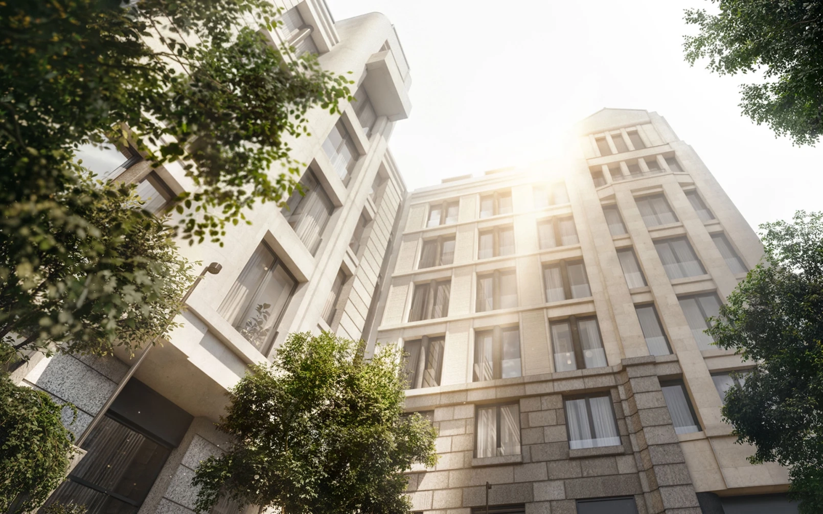 Дневной вид снизу вверх на жилой комплекс, демонстрирующий архитектурные детали светлых фасадов в окружении зеленых насаждений