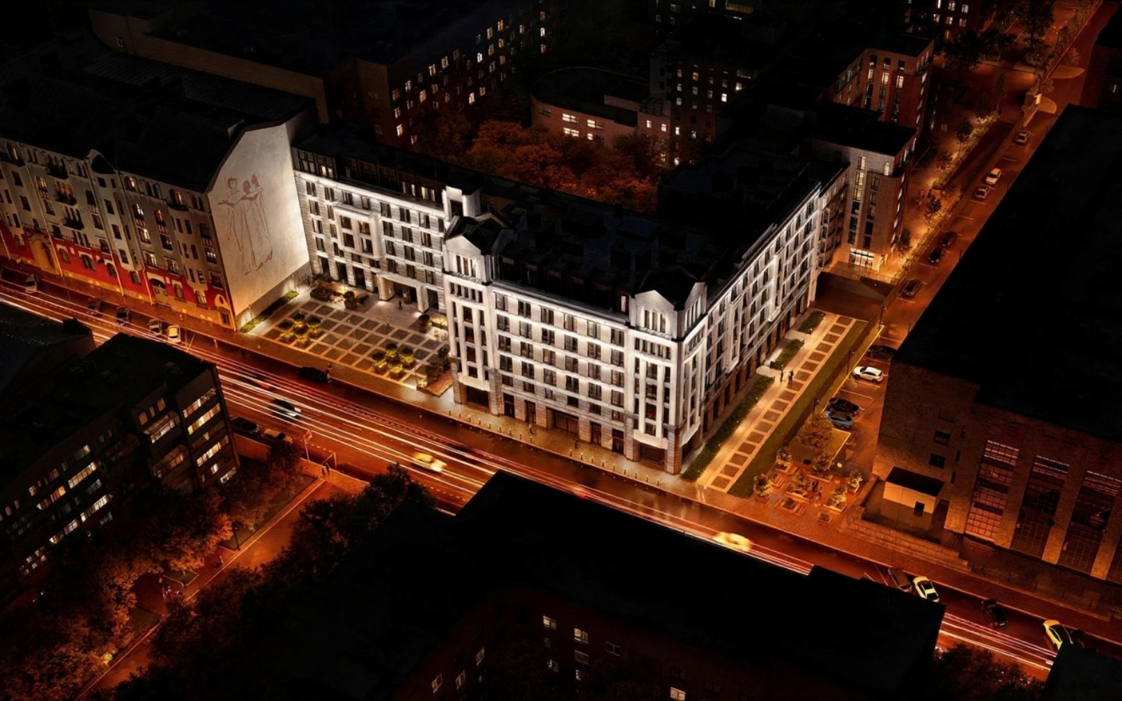 Аэрофотосъемка жилого комплекса ночью с высоты птичьего полета, показывающая весь квартал с подсветкой и окружающую городскую инфраструктуру